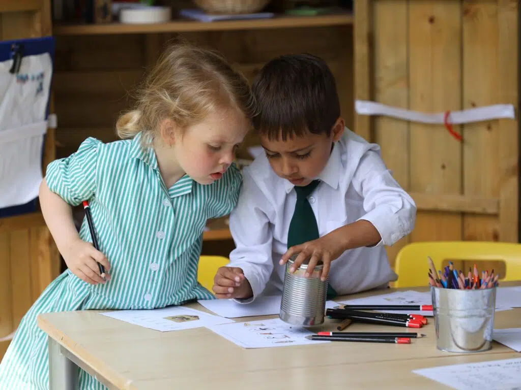 Early Years pupils drawing outside the Pre-Reception classroom