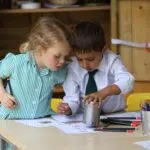 Early Years pupils drawing outside the Pre-Reception classroom