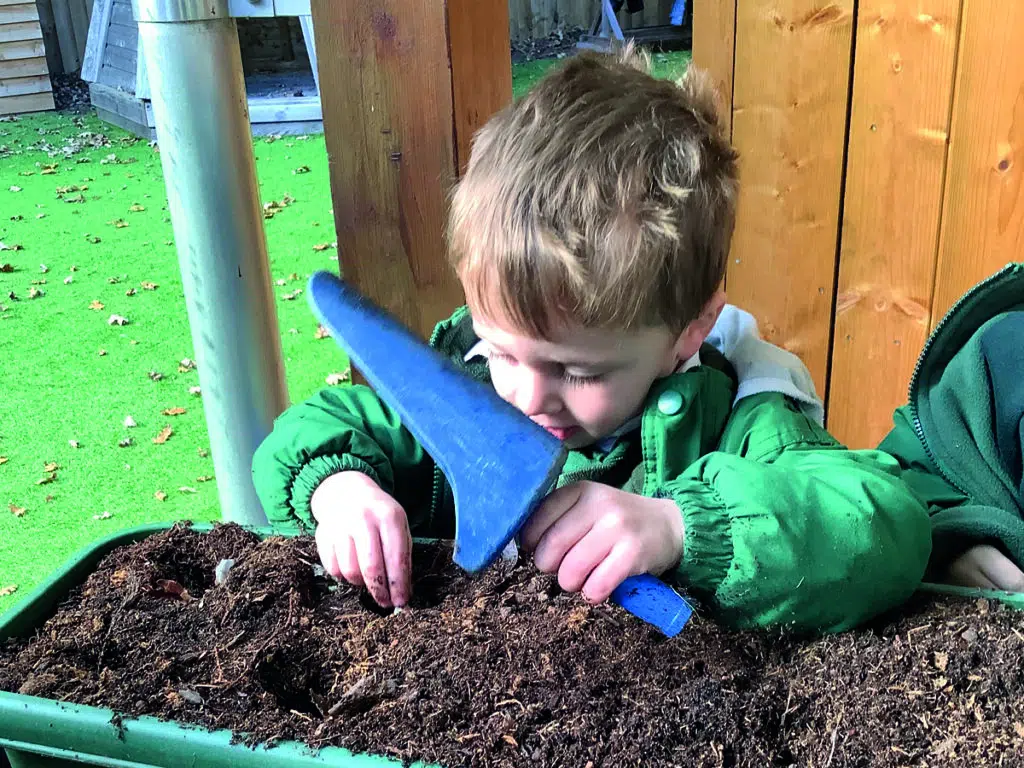 Early Years pupil gardening