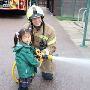 Early Years pupil with a fir hose