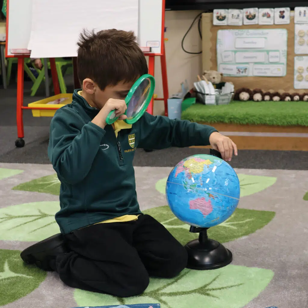 Early Years pupil looking at a globe