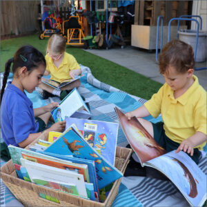 Early Years pupils reading on a blanket