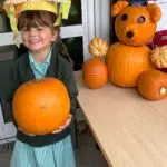 Early Years pupil with a pumpkin