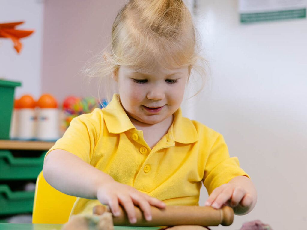 Early Years pupil rolling dough