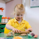 Early Years pupil rolling dough